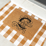 clay/monogram doormat